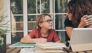 image of mother working from home helping son with homework