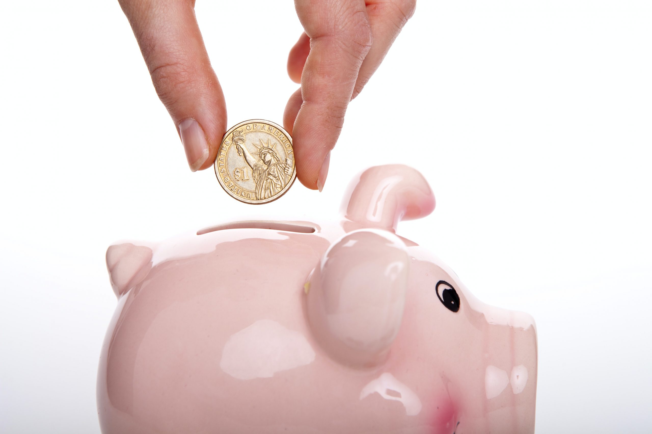 woman placing coin in piggy bank