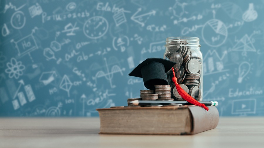 College fund savings jar with coins and graduation cap